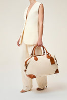 TUSTING COMO Explorer medium top handle bag in cream with gold hardware and structured design.