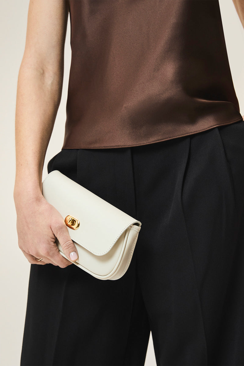 TUSTING Hettie in Cloud clutch bag with soft pastel blue fabric and sleek design, ideal for elegant evening accessories.