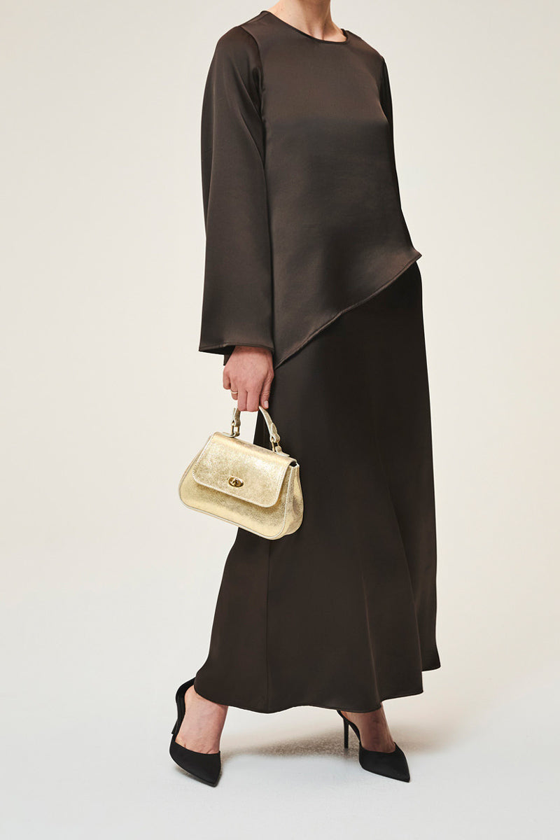Mini Holly in gold suede top handle bag by TUSTING, featuring a compact design with elegant gold accents and a sleek finish.