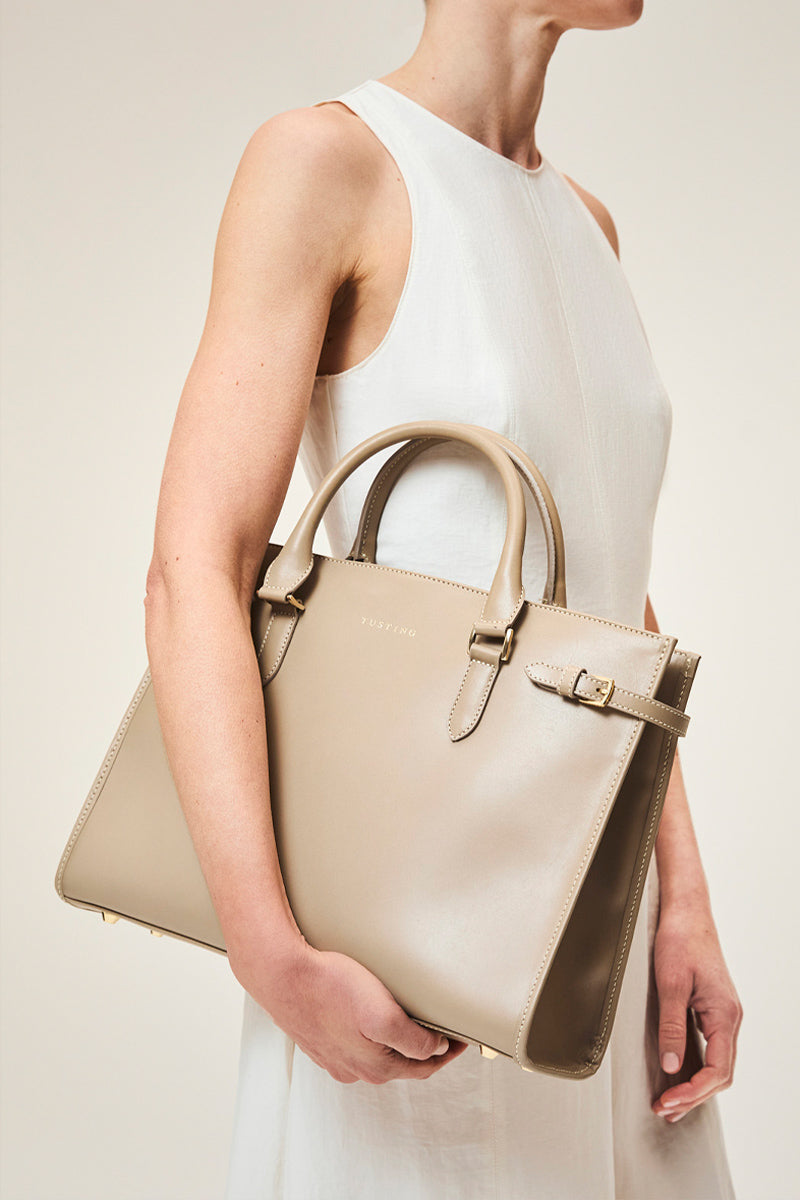 Taupe TUSTING KIMBOLTON top handle bag with sleek design and structured shape, featuring sturdy handles and elegant details.