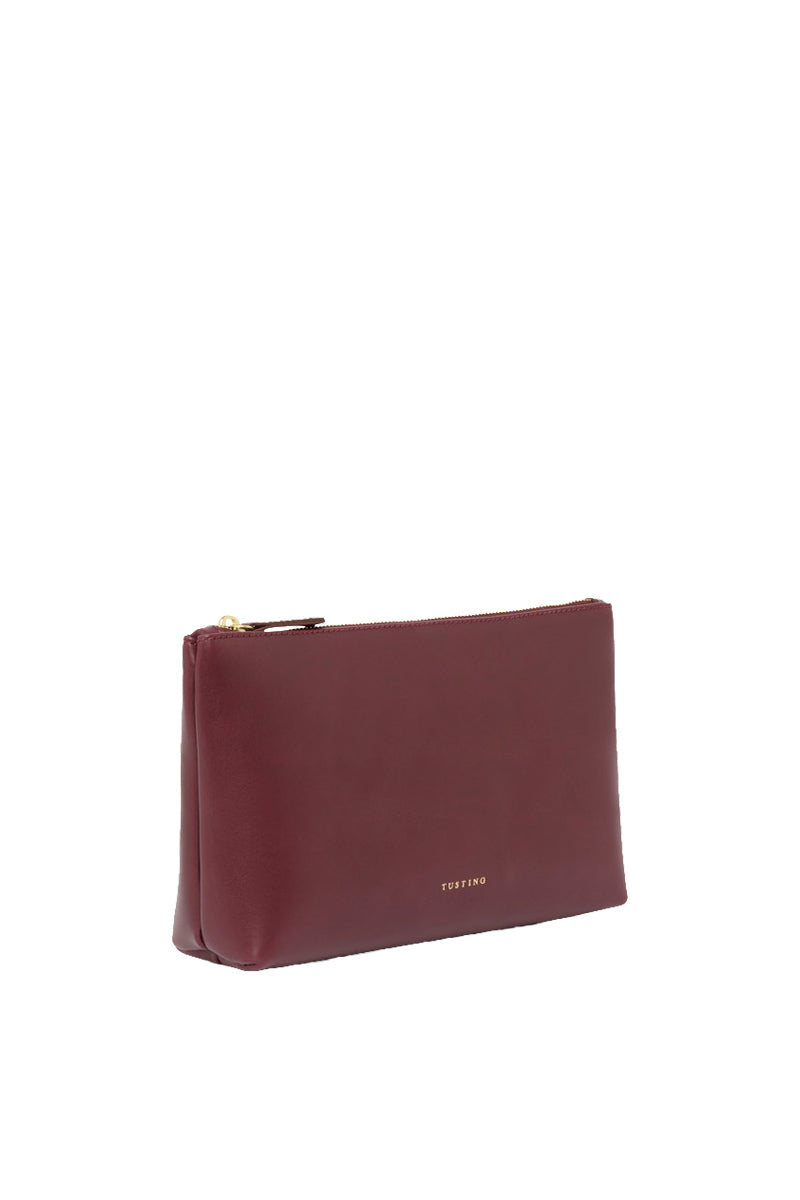 TUSTING leather top handle pouch in oxblood color with a sleek, compact design and gold-tone hardware.