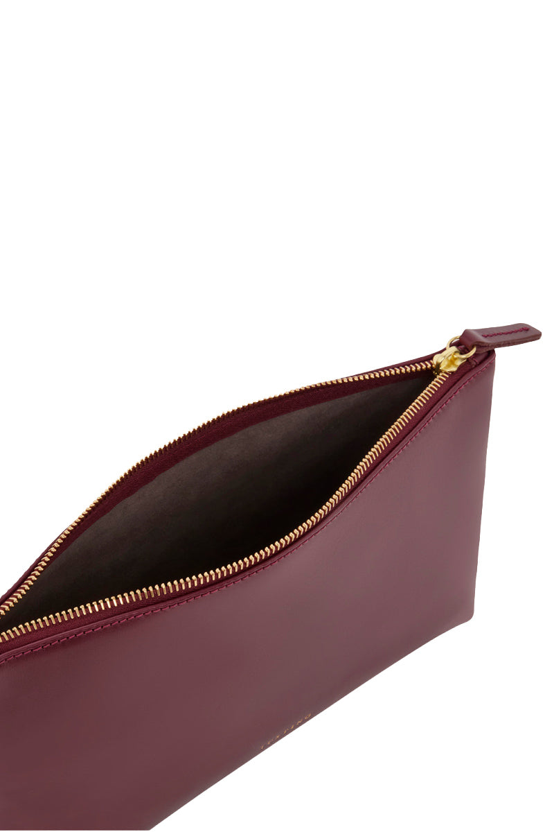 TUSTING oxblood leather top handle pouch bag with a sleek, compact design and sturdy strap for elegant carrying.