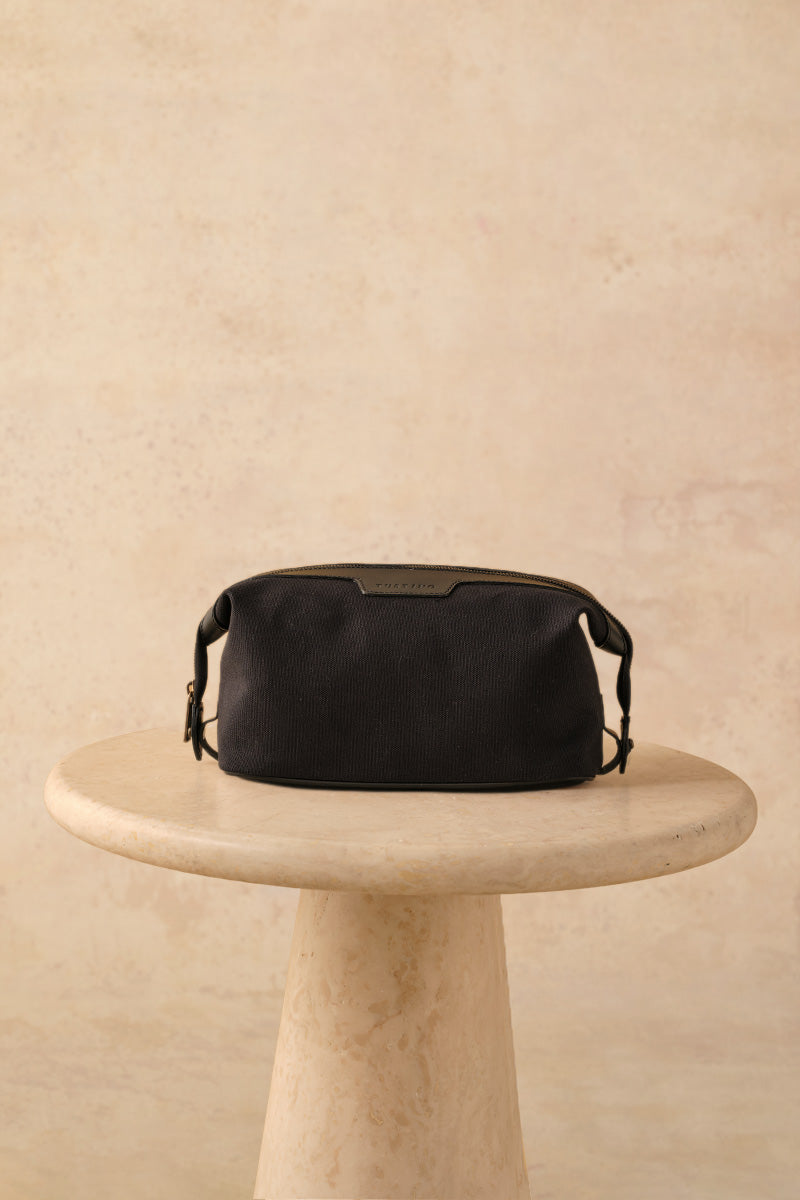 TUSTING Horizon canvas and leather top handle bag in Como canvas with black trim, featuring a stylish and durable design.