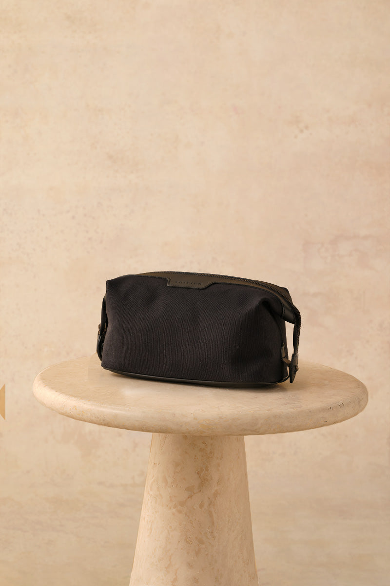 TUSTING Horizon canvas and leather top handle bag in Como canvas with black trim, featuring a stylish and functional design.