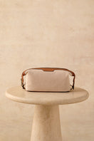 TUSTING Horizon canvas and leather clutch in Como canvas with tan trim, featuring a sleek design and compact size for everyday use.