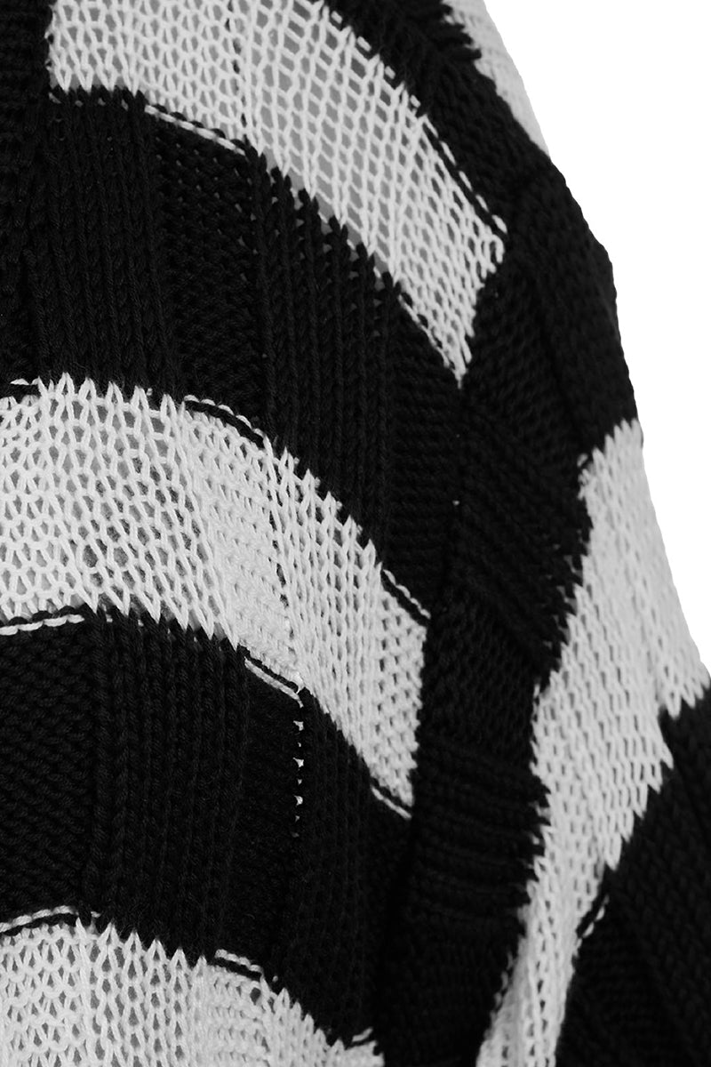 Two-tone knitted sweater in ivory and black by MAZ Manuela Álvarez, featuring a cozy, stylish design and textured knit fabric.