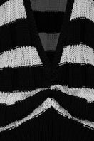 Two-tone ivory and black knitted sweater by MAZ Manuela Álvarez, showing close-up of textured fabric and fashionable design.