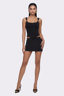 Black Tallulah mini skirt by Nana Jacqueline with ring cutout design, shown on a model in a fashion lookbook image.