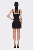 Black Tallulah mini skirt by Nana Jacqueline featuring ring cutout design and fitted silhouette.