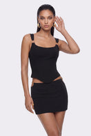 Black Tallulah mini skirt by Nana Jacqueline featuring ring cutout design, shown on a model in a stylish lookbook image.