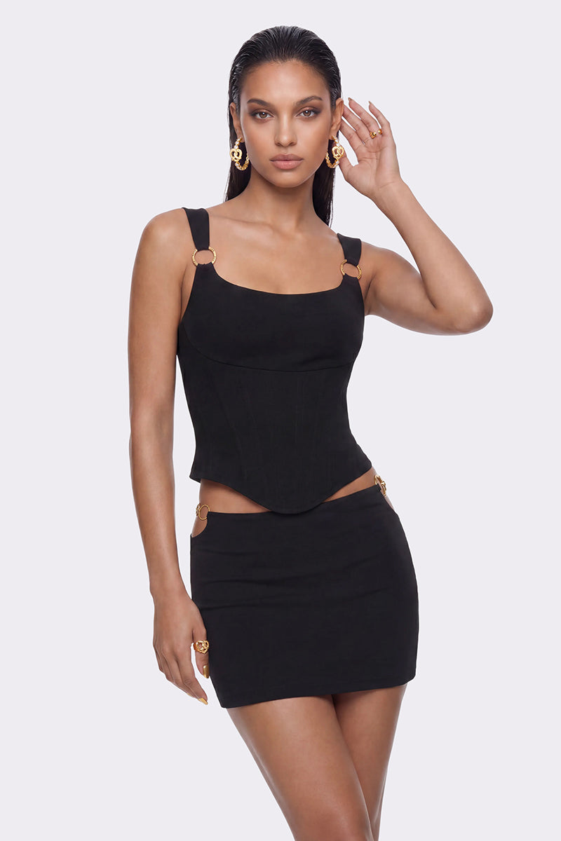 Black Tallulah mini skirt by Nana Jacqueline featuring ring cutout design, shown on a model in a stylish lookbook image.
