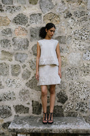 Light beige TATTI mini skirt by ANA + MARIA, shown on a model with a relaxed fit and stylish design in a fashion campaign photo.