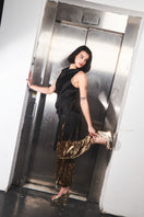 Gold heels by Terry de Havilland featuring a sleek design and pointed toes, showcased on a neutral background.