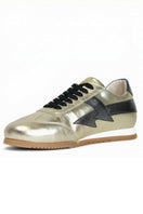 Black and gold Terry de Havilland jogger bolt sneaker with flat design and stylish details, showcasing the luxury footwear style.