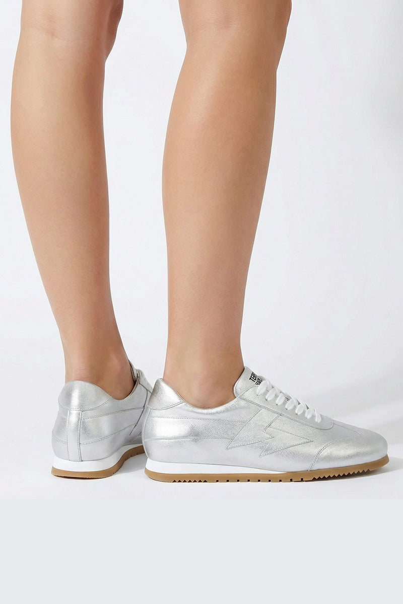 Silver Terry de Havilland jogger bolt flats worn on legs, showcasing stylish, metallic footwear with a sleek design.