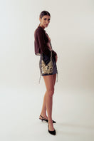 Silver shoulder bag from Millanne Tale featuring a sleek metal design and a stylish strap for versatile wear.
