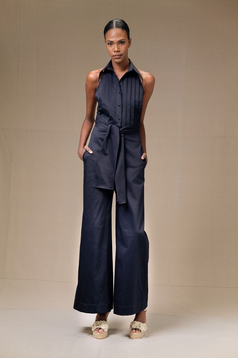 Navy blue ANA + MARIA wrapped jumpsuit with long sleeves and waist tie, displayed on a hanger.