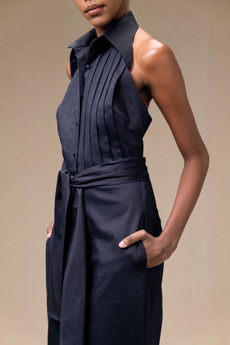 Navy blue ANA + MARIA wrapped jumpsuit featuring a fitted waist and long sleeves, displayed on a mannequin.