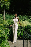 ANA + MARIA wrapped jumpsuit in sand, featuring a stylish design, tied waist, and lightweight fabric for a chic, casual look.