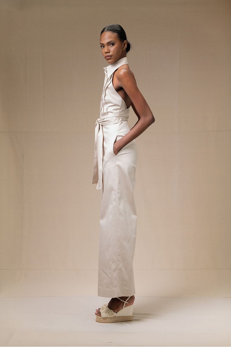 Cream-colored ANA + MARIA wrapped jumpsuit in sand fabric, featuring a flattering waist tie and wide-leg design.