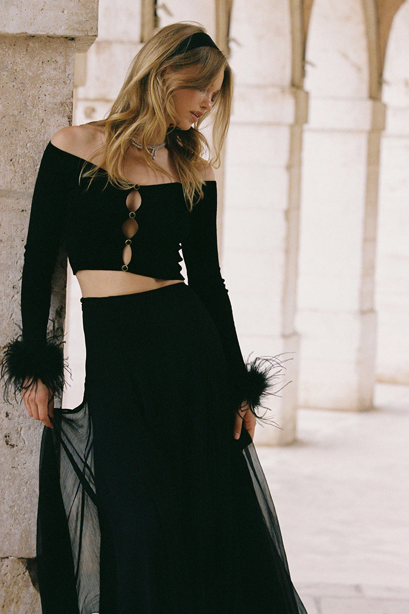 Black Nana Jacqueline Thea Top made of soft fabric, displayed on a mannequin with a sleek, modern design.