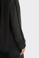Black Thread Coat by Stolen Stores, stylish outerwear with a sleek design, shown on a model in a fashion photoshoot.