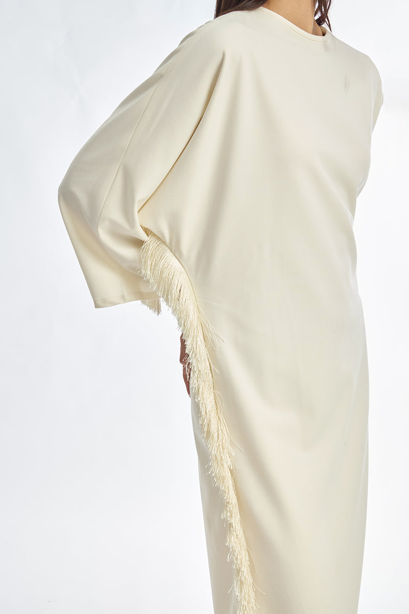 Ivory white maxi dress with long sleeves and thread fringe detail by Stolen Stores, shown on a model.