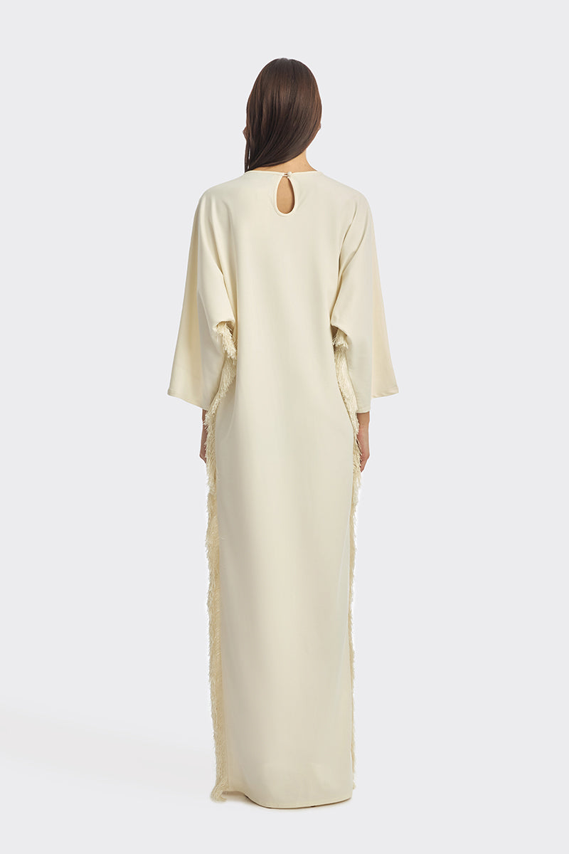Ivory white maxi dress with long sleeves and thread fringe details, styled by Stolen Stores.