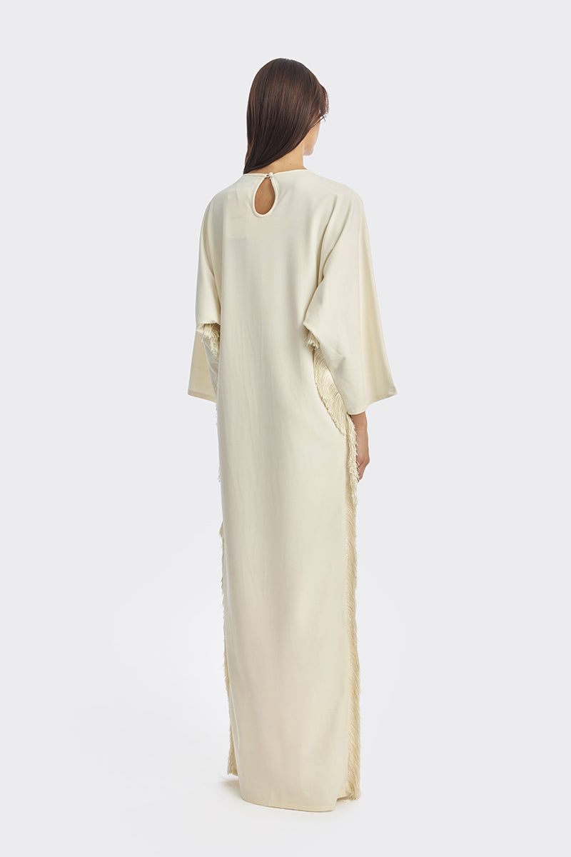 Ivory white maxi dress with long sleeves and thread fringe details by Stolen Stores, elegant and flowing for a stylish look.