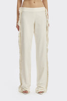 Ivory white thread fringe maxi pants by Stolen Stores featuring flowing fabric and intricate fringe detailing.