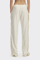 Ivory white thread fringe maxi pants from Stolen Stores with intricate fringe detailing and relaxed fit.