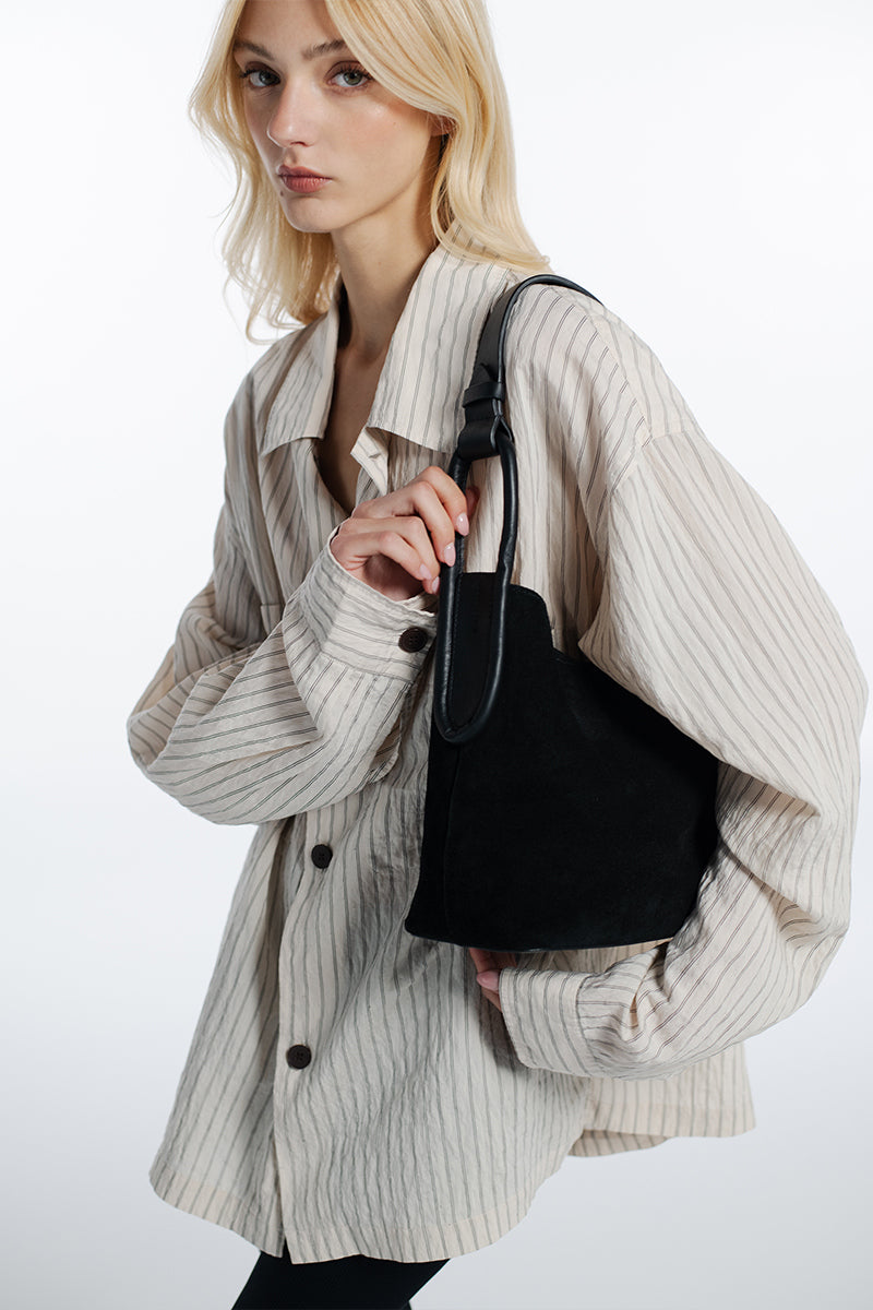 Black suede TIERRANUEVA tote bag with top handles by ISIDORA MALVA, showing its textured surface and elegant design.