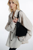 Black suede TIERRANUEVA tote bag with top handles by ISIDORA MALVA, showing its textured surface and elegant design.