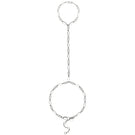 Silver hand chain bracelet from Velvet Desert's Toulouse collection featuring intricate silver design on a model's hand.