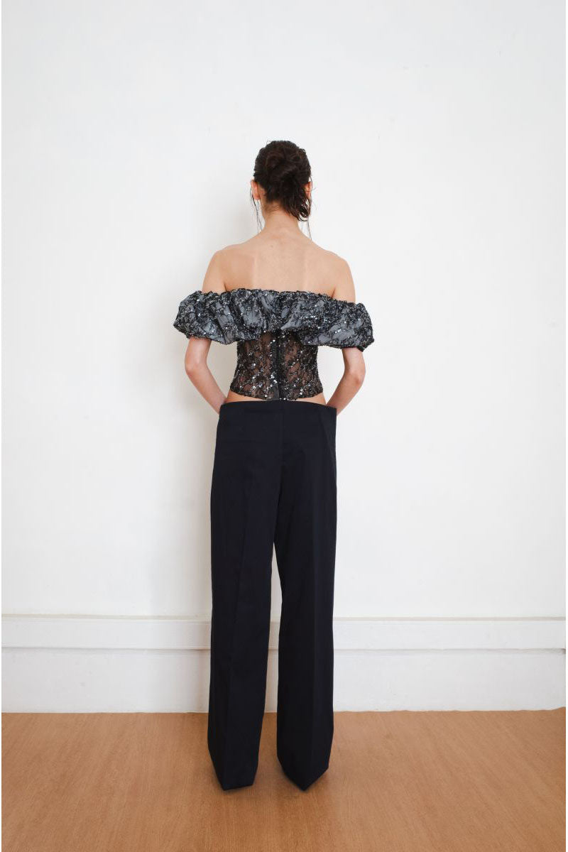 Black YASSMIN SALEH TRACE corset top displayed from the back, showcasing the fitted design and lace-up detail.