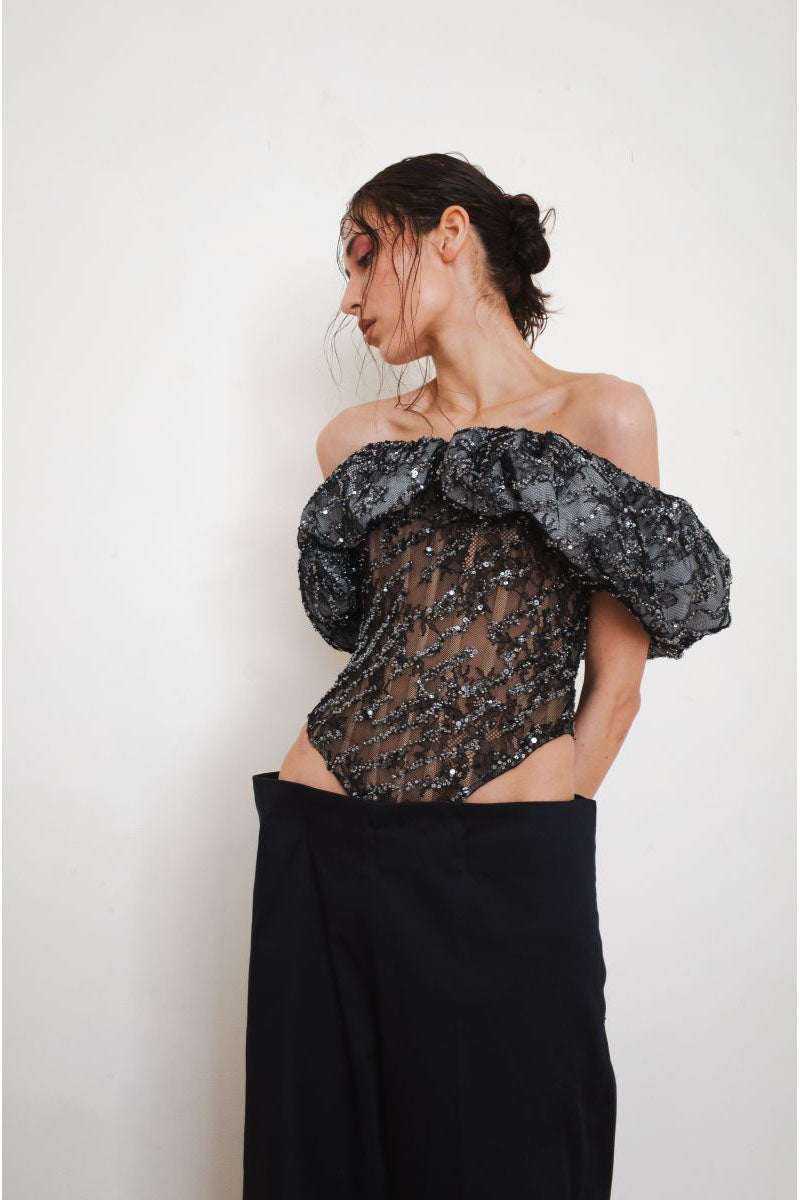 Black TRACE corset top by YASSMIN SALEH, featuring structured design and front view with lace-up details.