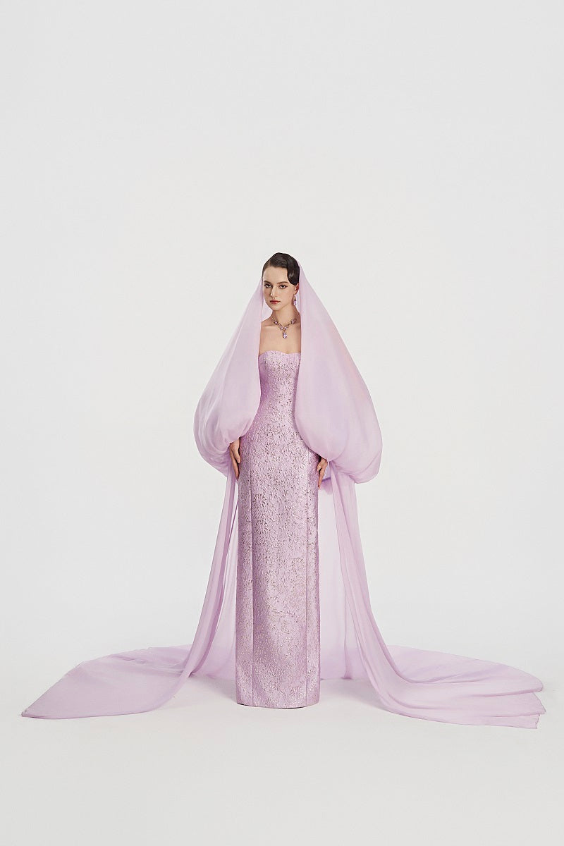 Elegant jacquard maxi gown with a hooded veil cape by Tracy Studio, featuring intricate patterns and flowing fabric.