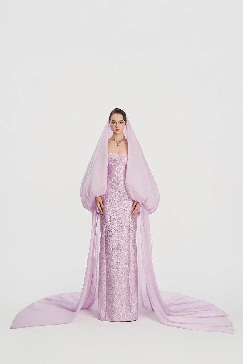 Elegant Jacquard gown with a hooded veil cape by Tracy Studio, featuring intricate patterns and flowing maxi dress design.