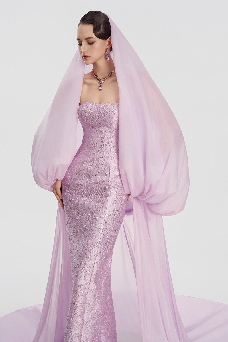 Elegant jacquard maxi gown with a hooded veil cape by Tracy Studio, showcasing intricate fabric and a flowing silhouette.