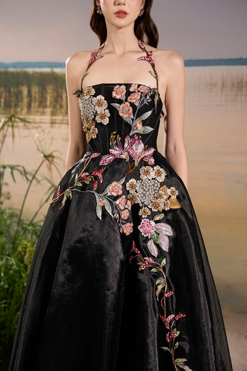 Black Tracy Studio maxi dress with organza floral bead embellishments, featuring elegant detailing and a flowing silhouette.