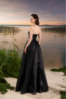 Black Tracy Studio gown with floral bead embellishments and organza fabric, featuring a flowing, elegant design.