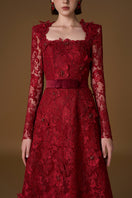 Red I.H.F gown with square guipure lace and silk, featuring a trapeze neckline and long sleeves in an elegant A-line design.