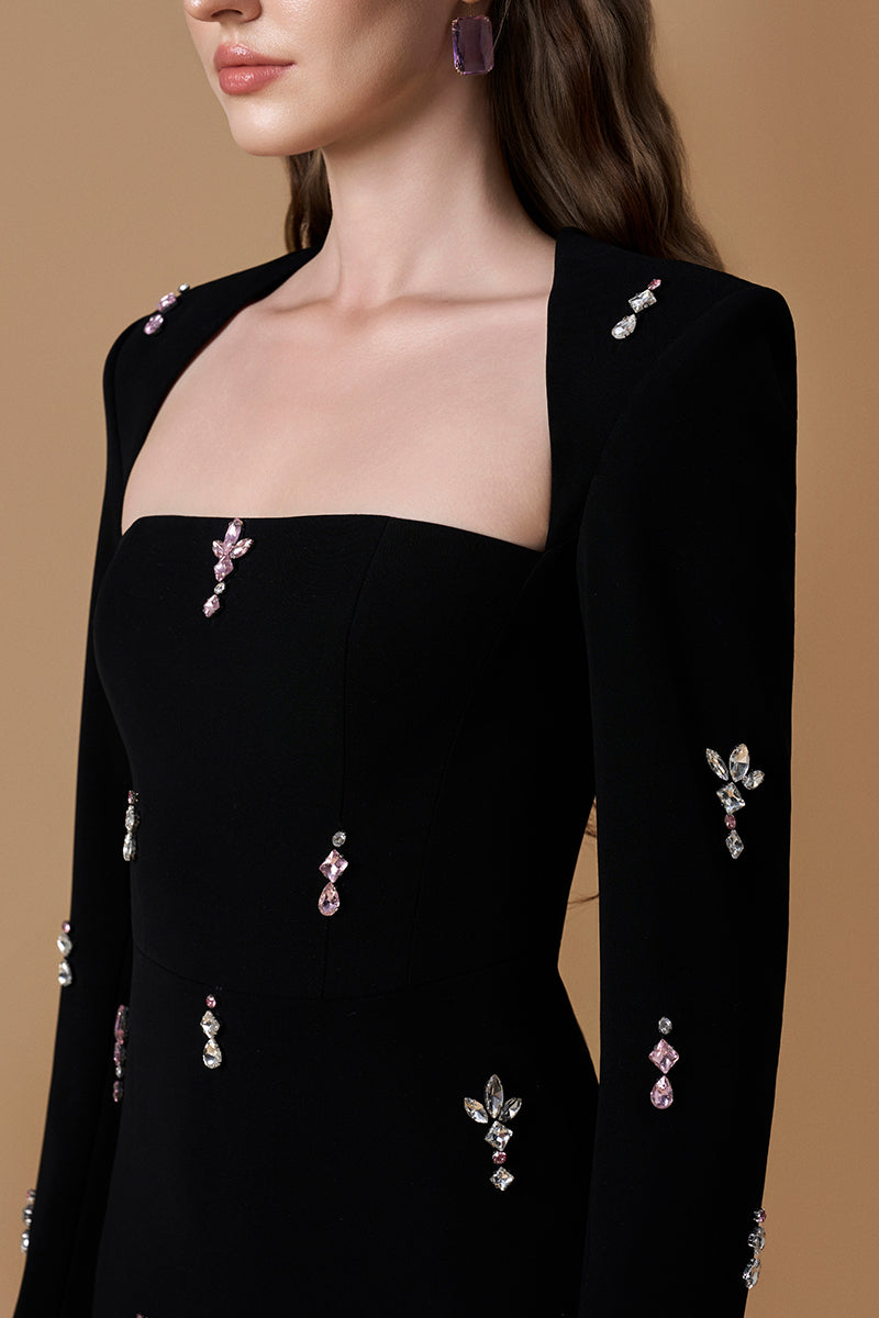 Black crepe maxi dress by I.H.F featuring a trapeze neckline, long sleeves, and elegant pink stone details.