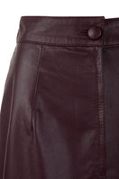 Wine red leather maxi skirt with a tube petal design from MAZ Manuela Álvarez, displayed on a model.