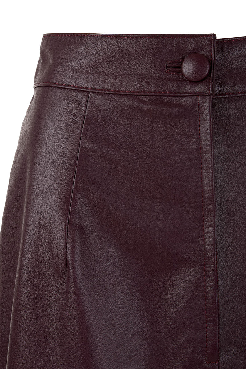 Wine red leather maxi skirt with a tube petal design from MAZ Manuela Álvarez, displayed on a model.