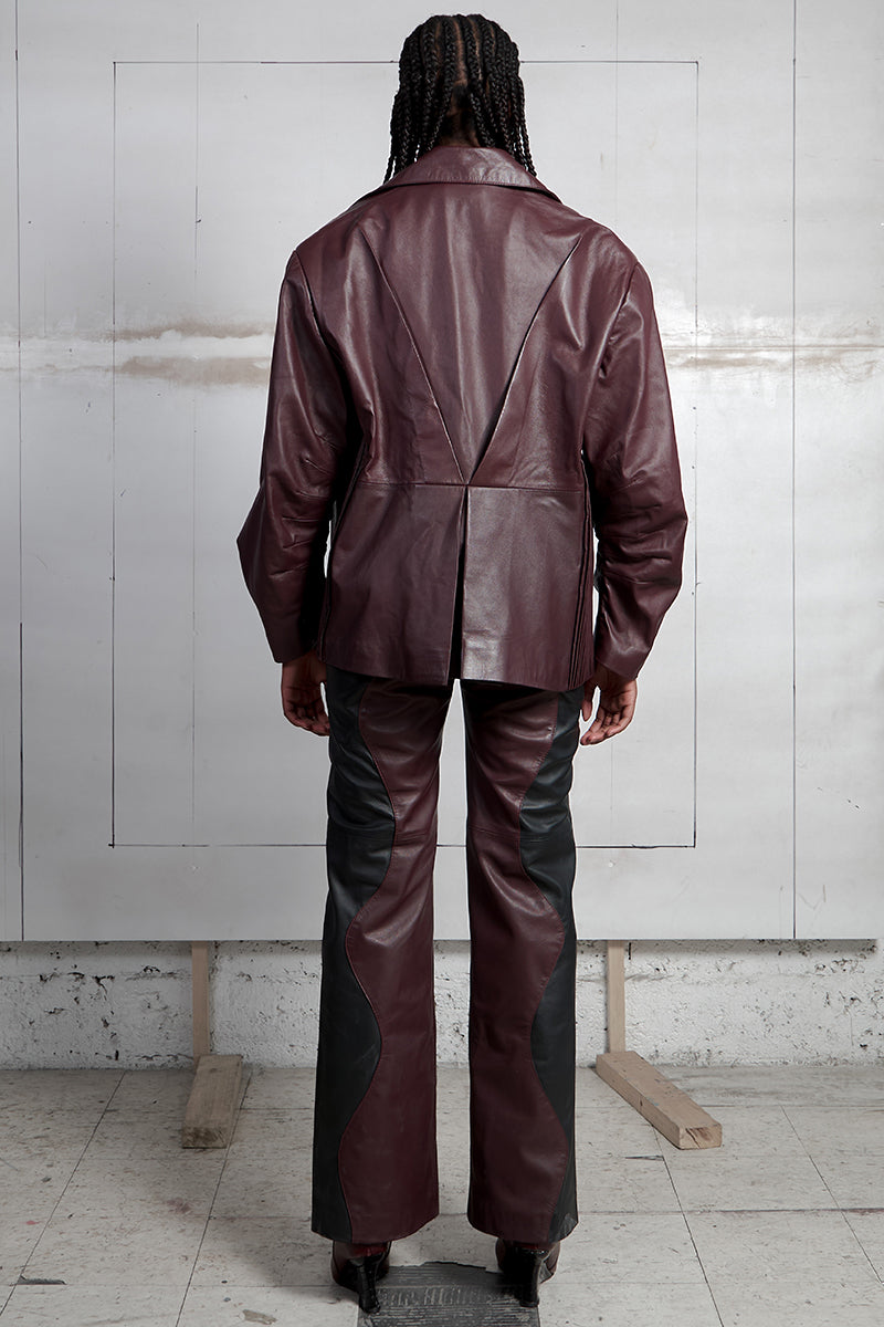 Black and wine red two-tone leather trousers by MAZ Manuela Álvarez featuring mountain-inspired design and slim fit style.
