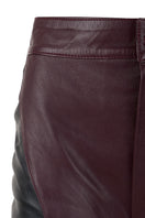 Black and wine red two-tone leather mountains trousers by MAZ Manuela Álvarez, stylish pants with contrasting color blocks.