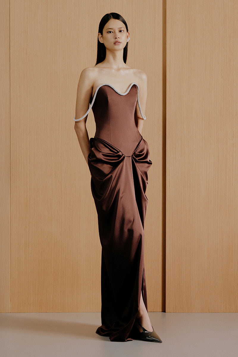 Brown Urban Muse Evaina gown with flowing fabric and elegant design, showcased on a model.