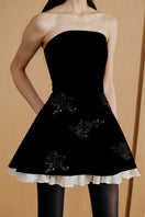 Black Urban Muse velours mini dress, close-up of the fitted silhouette and soft fabric detail.