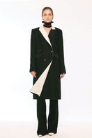 Vaska black double-breasted white collar coat displayed on a model, showcasing its tailored fit and classic style.